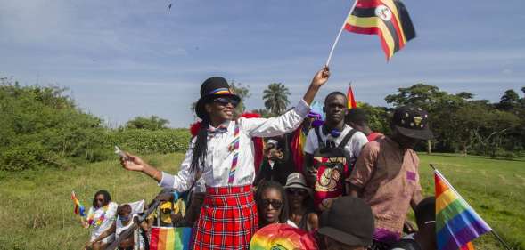 People waving Ugandan and rainbow flags take part in the Gay Pride parade in Entebbe on August 8, 2015. Ugandan activists gathered for a gay pride rally, celebrating one year since the overturning of a strict anti-homosexuality law but fearing more tough legislation may be on its way. Homosexuality remains illegal in Uganda, punishable by a jail sentence. AFP PHOTO/ ISAAC KASAMANI (Photo credit should read ISAAC KASAMANI/AFP/Getty Images)