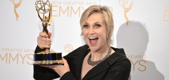 Jane Lynch holding an Emmy Award