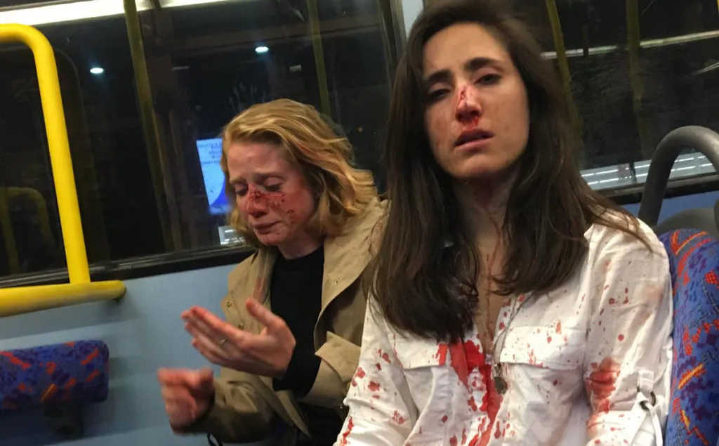 Two women on a bus covered in blood