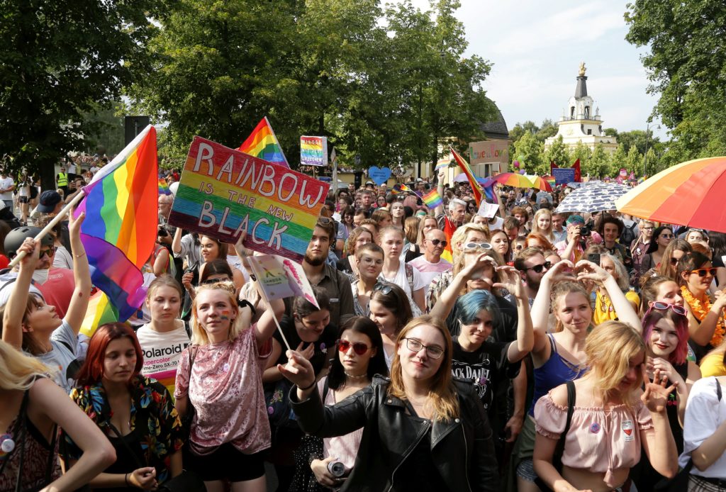 People hold flags and placards during the first gay pride march on July 20, 2019 in Bialystok 