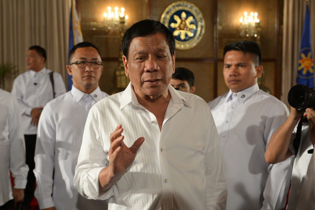 Rodrido Duterte flanked by two other men