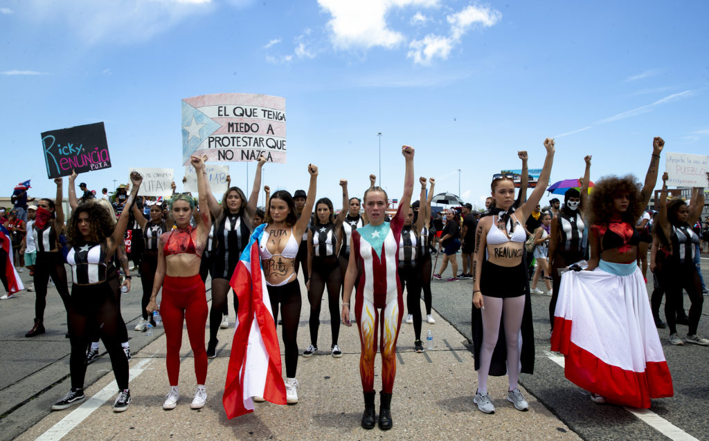 Women protestors stand in the middle of a highway
