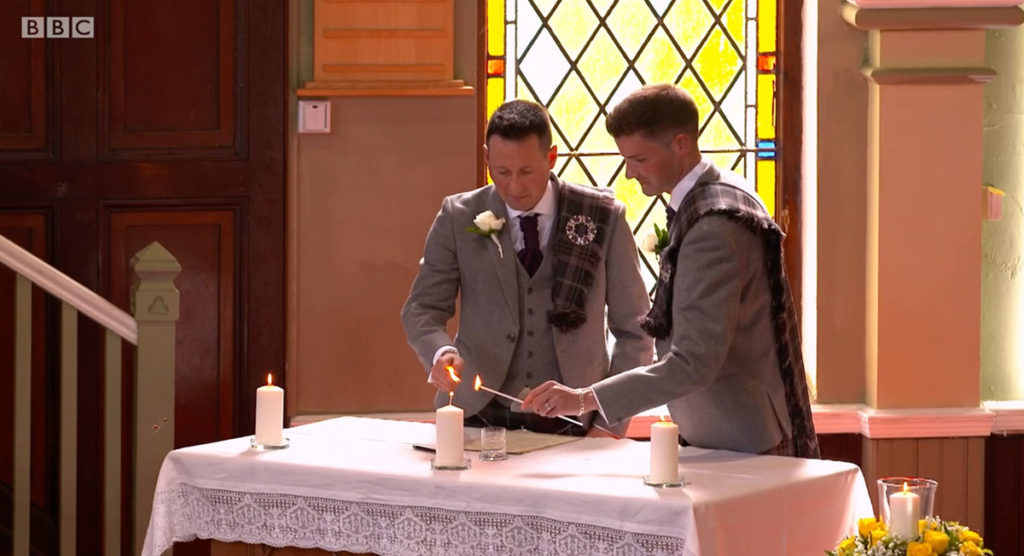 Jamie Wallace and Ian McDowall lighting a candle together.