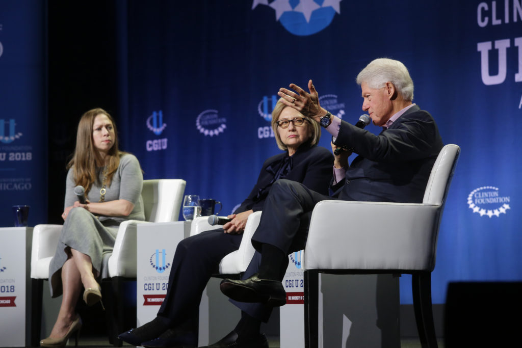 Chelsea Clinton (L), and former Secretary of State Hillary Clinton (C) listens as former President Bill Clinton speaks. (Joshua Lott/Getty Images)