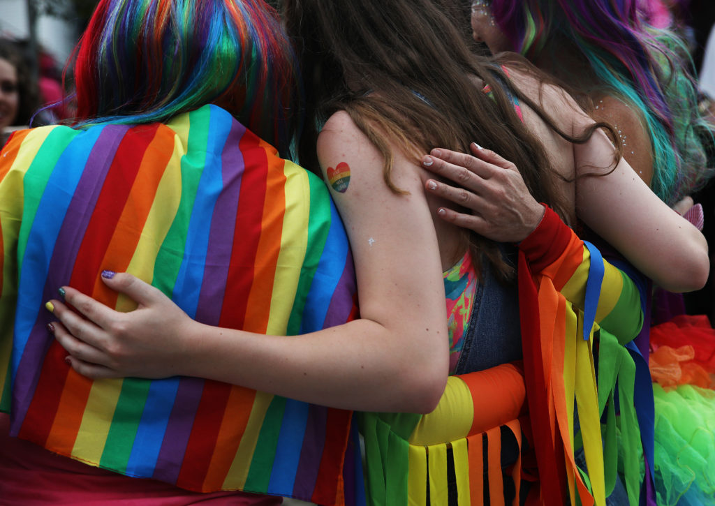 People embrace for a photo while attending Nashua Pride. (Erin Clark for The Boston Globe via Getty Images)