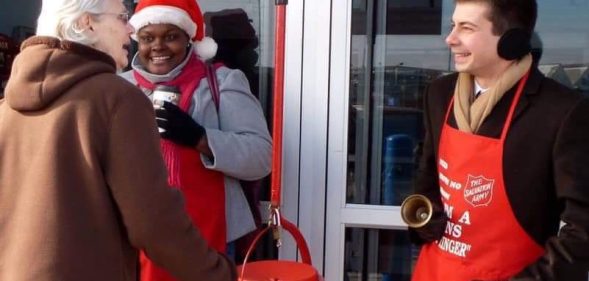 An old photograph of Pete Buttigieg ringing the signature bells of the Salvation Army has incited criticism online. (Twitter)