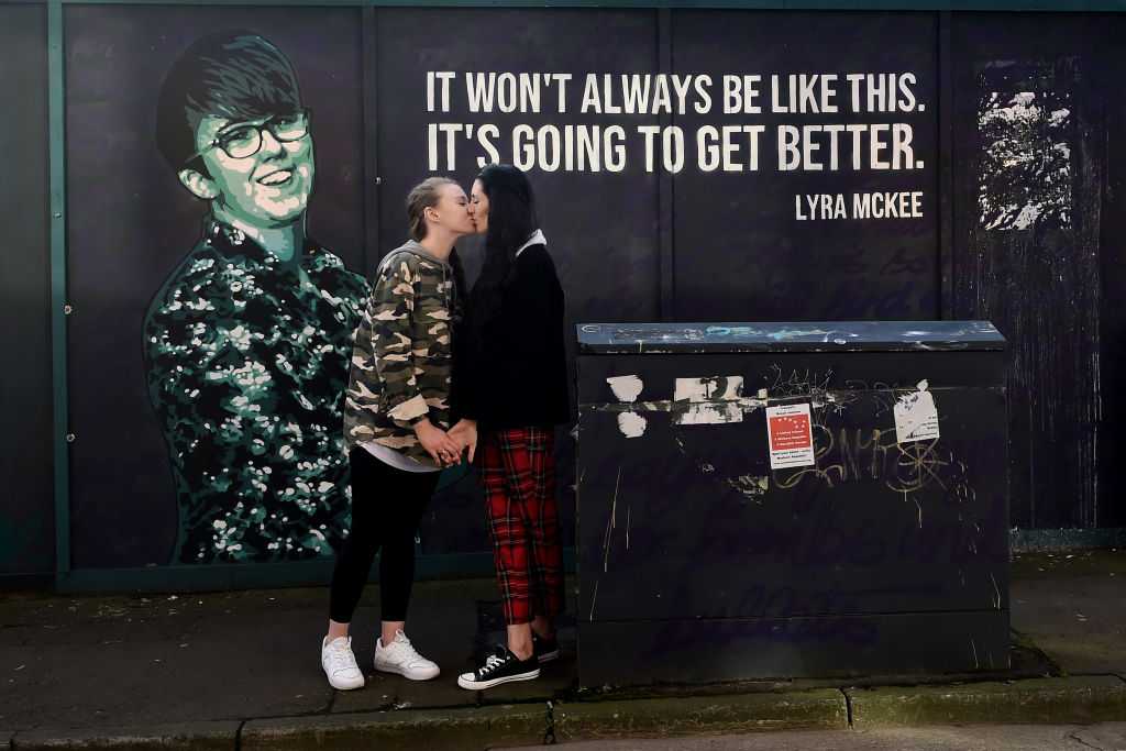 Robyn Peoples and Sharni Edwards, Northern Ireland's first same-sex couple to be legally married embrace and kiss in front of the Lyra McKee mural during a photo call on February 5, 2020 in Belfast, Northern Ireland.