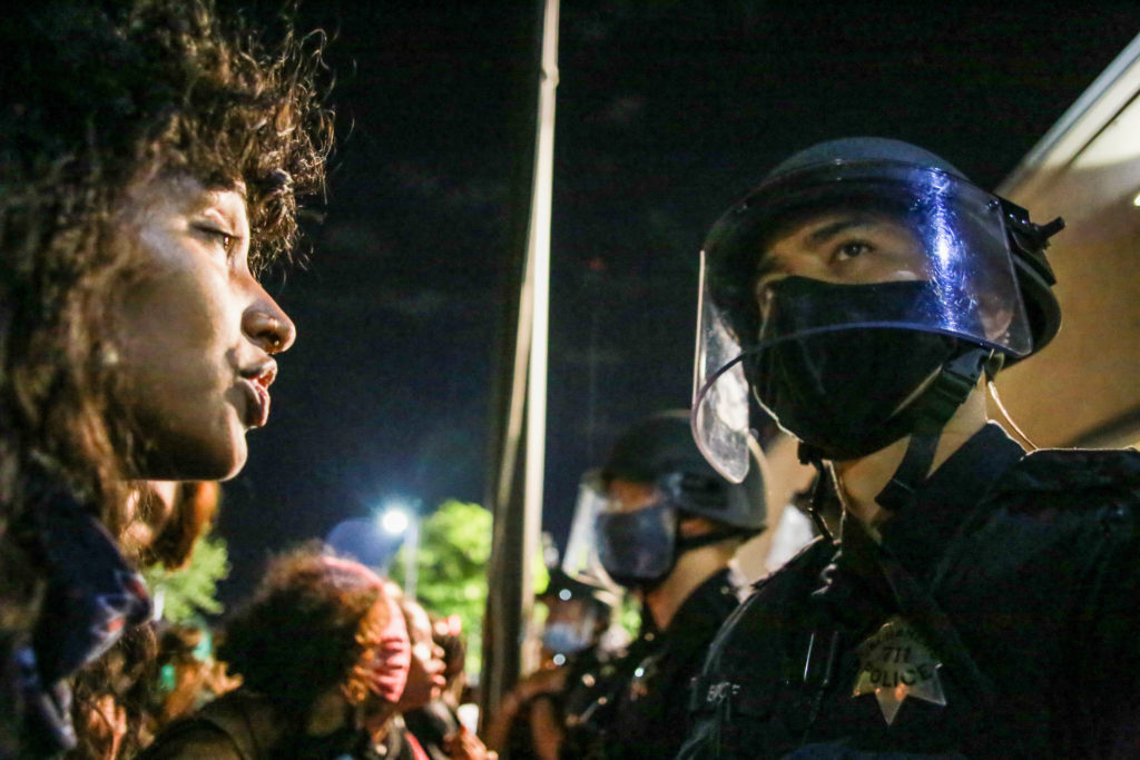 A protester stands face to face with a police officer during a peaceful Black Lives Matter demonstration in 2020. (Stanton Sharpe/SOPA Images/LightRocket via Getty Images)