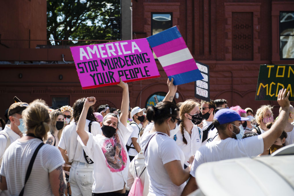 Protestors march with chants, trans Pride flags, signs and white clothing in support of Black Trans Lives Matter on June 14, 2020. (Michael Noble Jr./Getty Images)