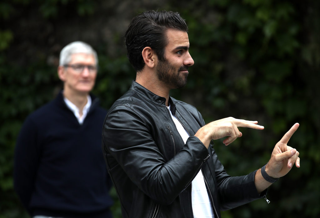 Apple CEO Tim Cook (L) looks on as actor, model, and activist for the deaf community Nyle DiMarco speak to students at the California School for the Deaf. (Justin Sullivan/Getty Images)