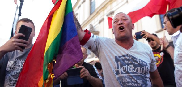 A man burns a LGBT flag during the anniversary of Warsaw Uprising in Warsaw, Poland