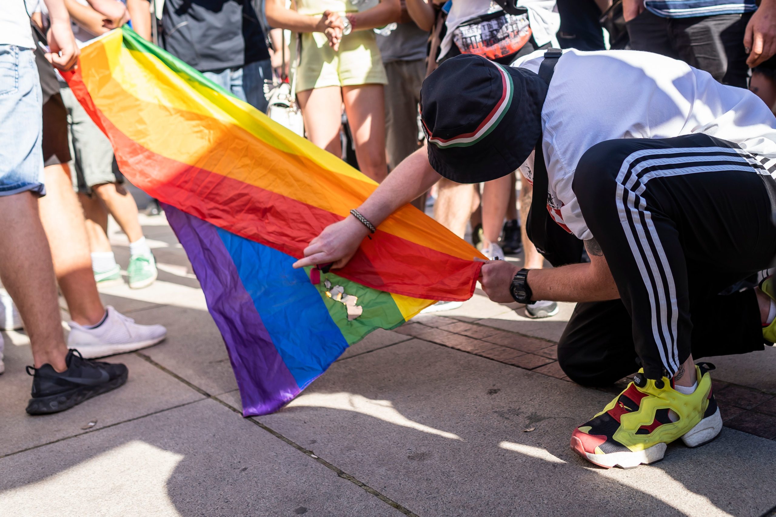 An activist attempts to burn a rainbow flag in front of the Warsaw University 