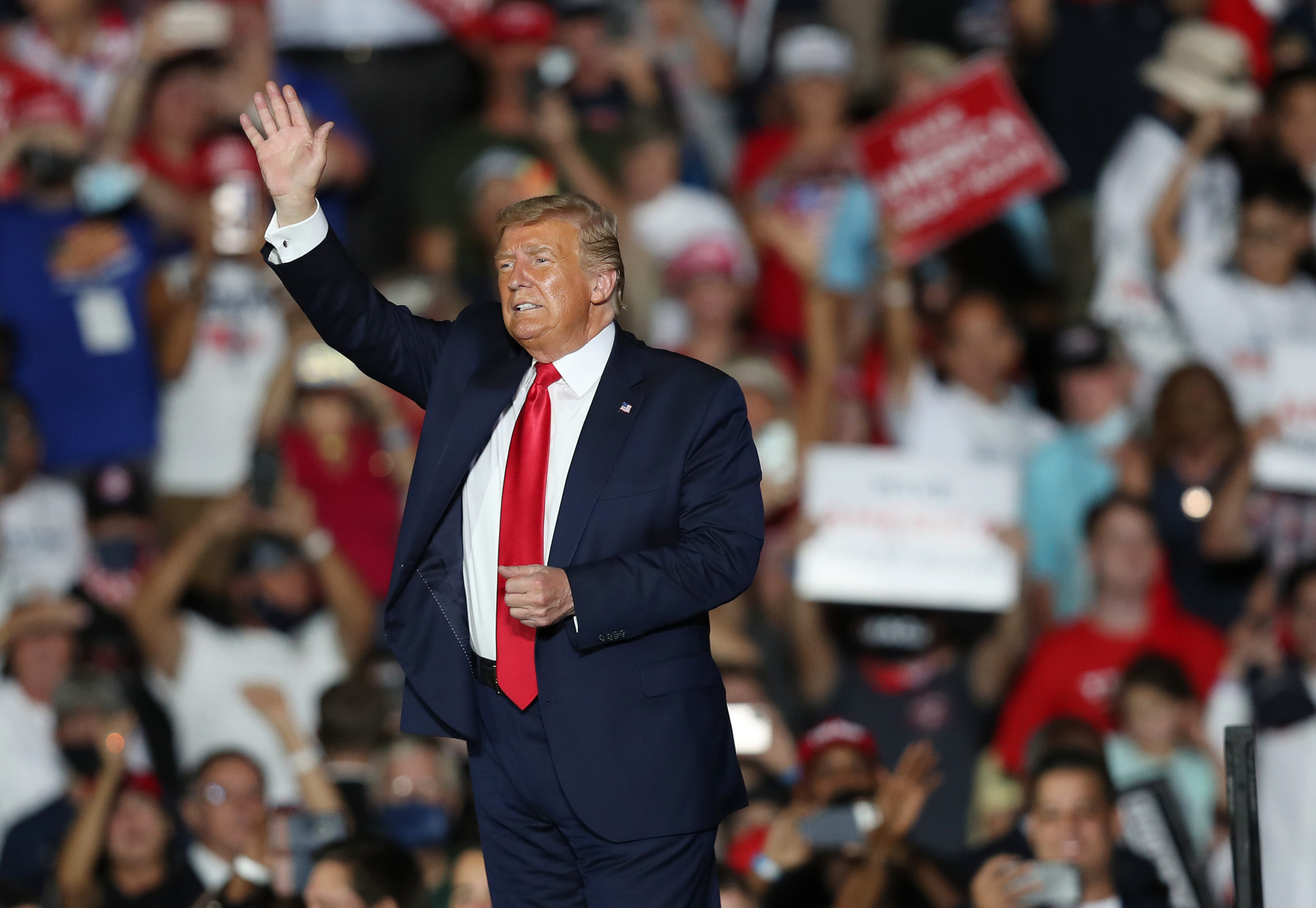 President Donald Trump waves to the crowd as he leaves after speaking during a campaign event at the Orlando Sanford International Airport on October 12, 2020 in Sanford, Florida. 