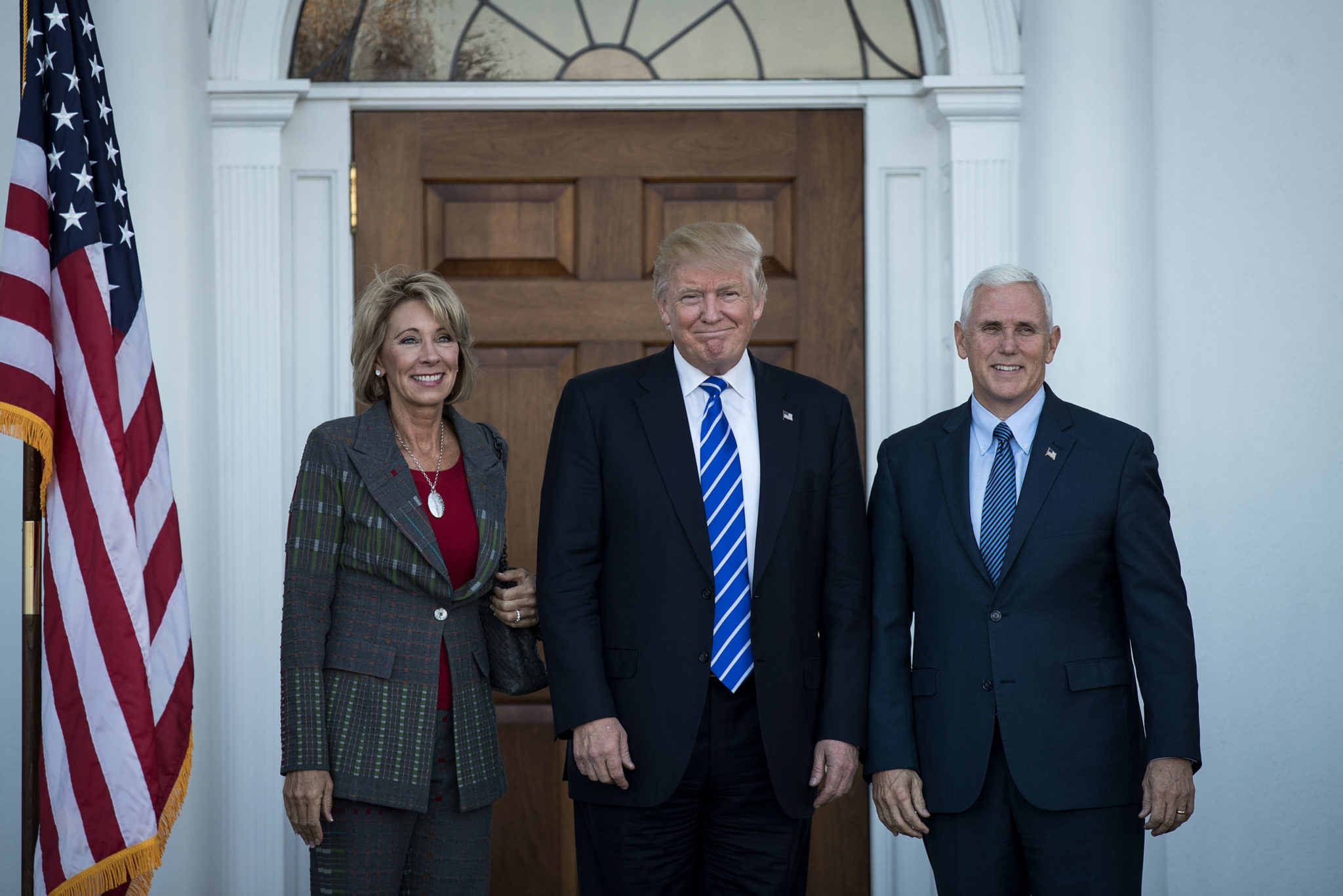 Education Secretary Betsy DeVos poses with Donald Trump and Mike Pence