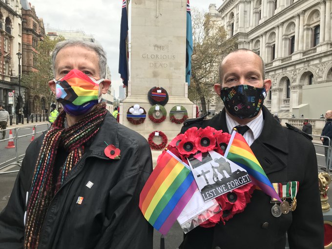 Peter Tatchell and David Bonney holding a rainbow poppy wreath at the Cenotaph