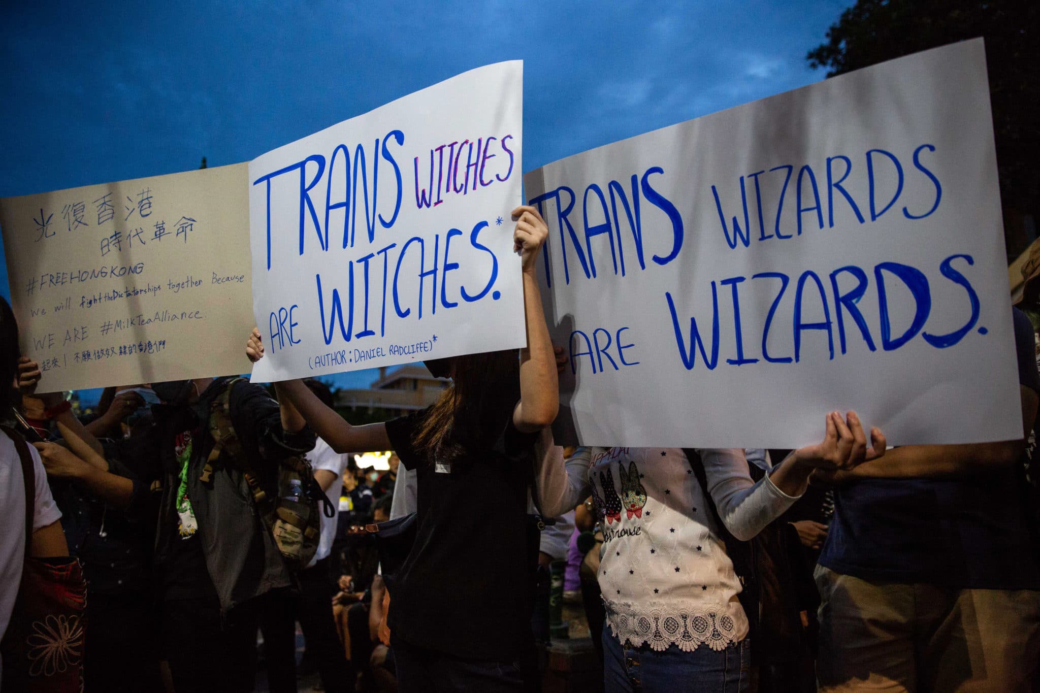 Protesters hold signs calling out JK Rowling as they take part in a Harry Potter themed on August 3, 2020 in Bangkok, Thailand.