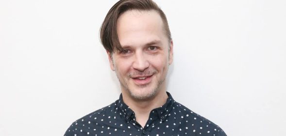 Michael Alig in a printed blue shirt against a white background