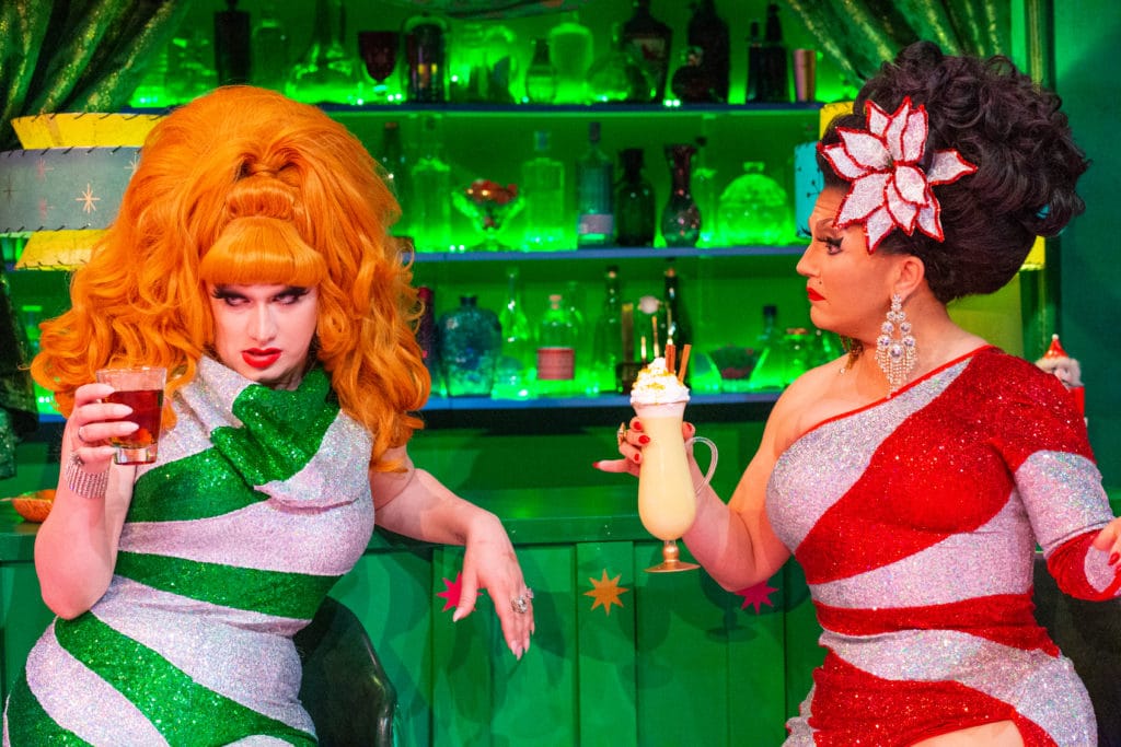 BenDeLaCreme and Jinkx Monsoon in matching candy-striped dresses, holding drinks