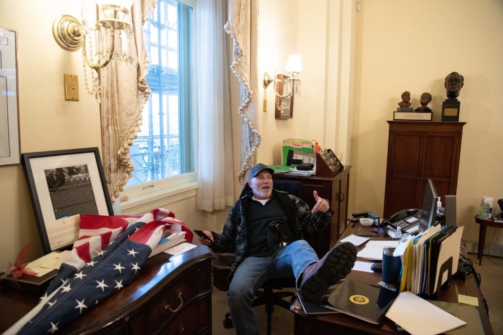 Richard Barnett, a supporter of US president Donald Trump sits inside the office of US speaker of the House Nancy Pelosi