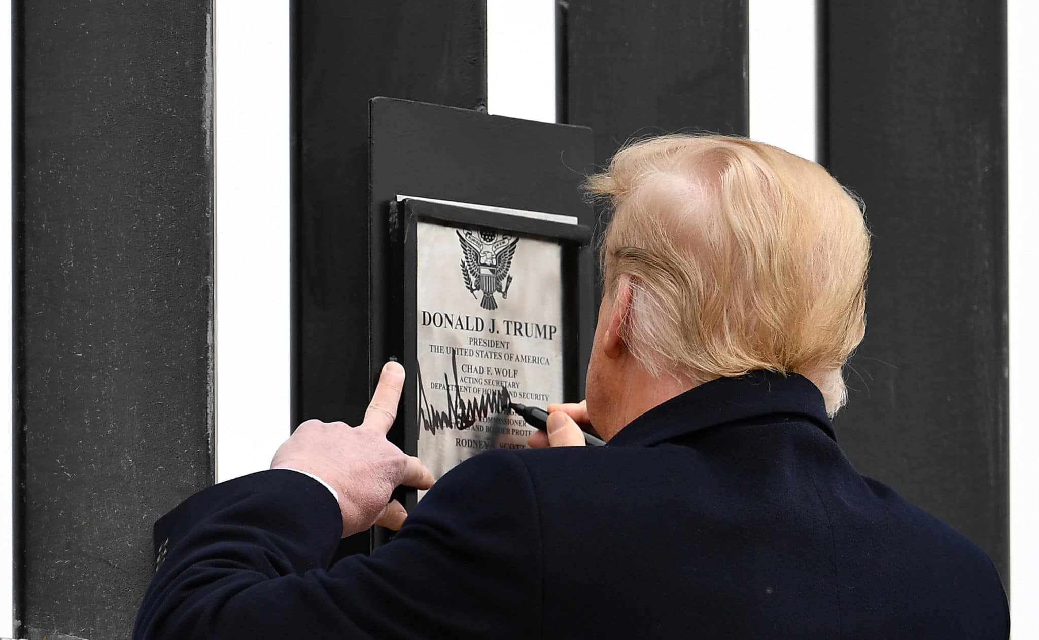 US President Donald Trump signs plaque on the border wall in Alamo, Texas on January 12