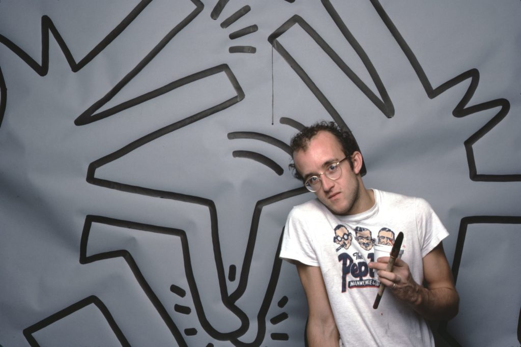 Keith Haring with one of his art works