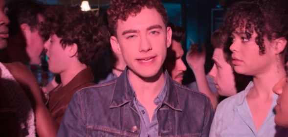 Olly Alexander surrounded by friends in a bar