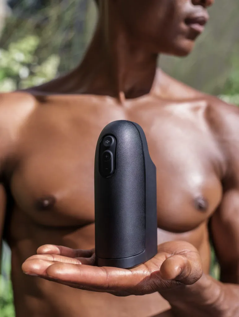 A topless man holding the Arcwave Ion, a sleek, black, phallic masturbator