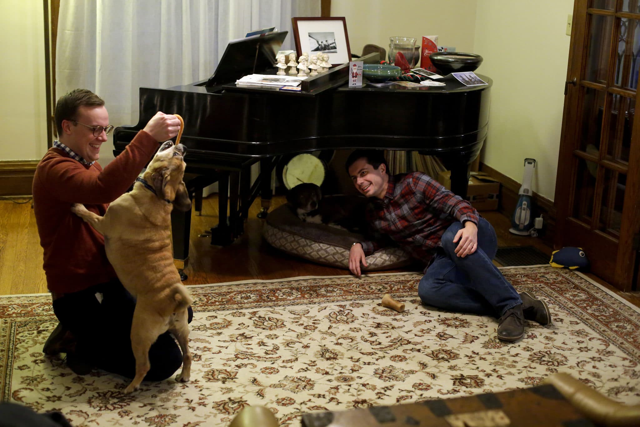 South Bend mayor Pete Buttigieg watches as his husband Chasten Glezman plays with their dog Buddy at their home on Tuesday 
