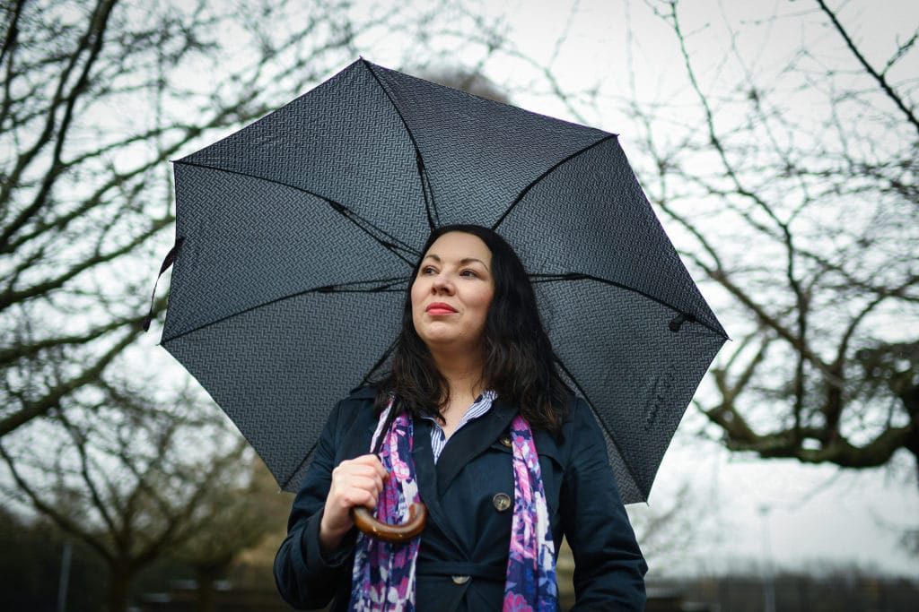 Monica Lennon holds an umbrella as she poses for a photograph