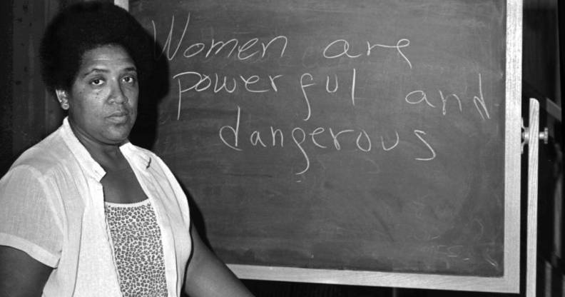 Audrey Lorde standing in front of a chalkboard with the message 'women are powerful and dangerous'