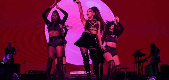 Ariana Grande and dancers on stage, drenched in pink lighting