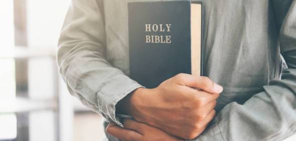 bible held in man's hands