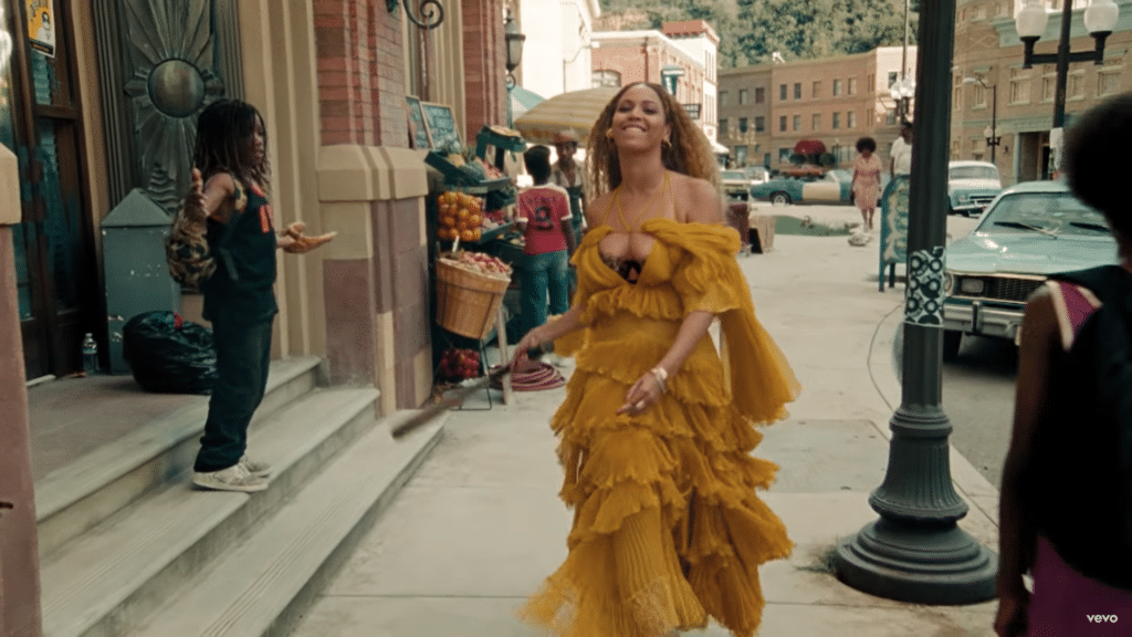 Beyoncé in a yellow dress holding a baseball bat