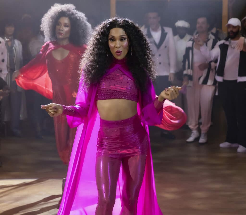 Mj Rodriguez as Blanca performing in the ballroom, wearing a pink crop top, legginga and cape