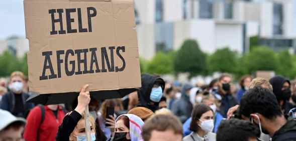 A participant holds up a placard reading 'Help Afghans' during a demonstration