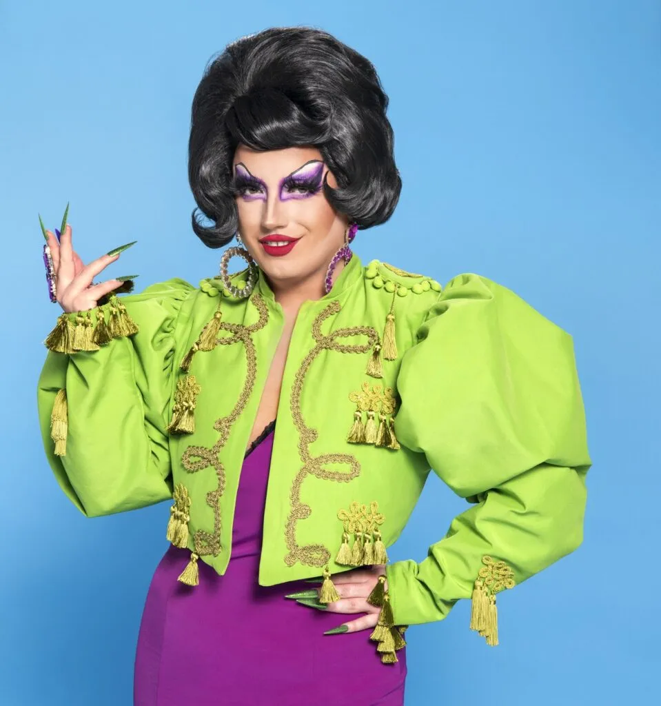 Drag Race UK queen Choriza May in a pruple dress with green jacket