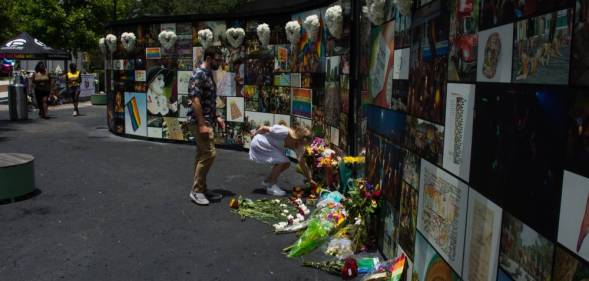 A person leaves flowers at the interim Pulse memorial