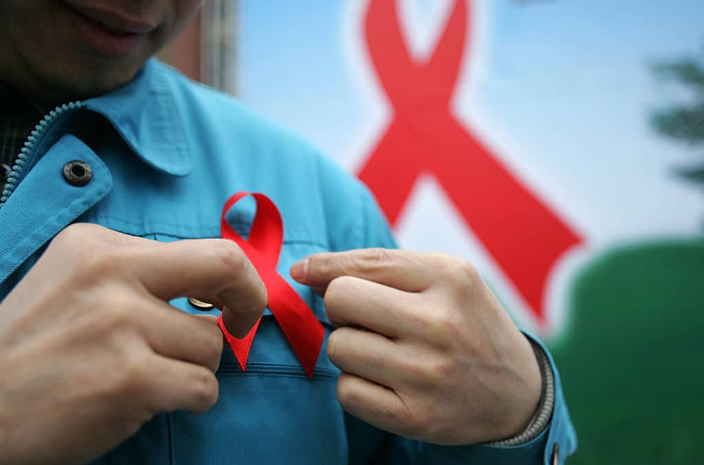 A migrant worker wears a red ribbon during an event organized by the local government to promote HIV/AIDS knowledge among migrant workers on December 1, 2005. 