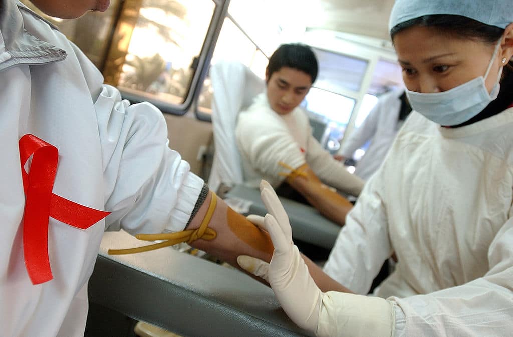 A nurse prepares to collect blood from a donor during a volunteer blood donation campaign to mark World AIDS Day on December 1, 2005 in China. 