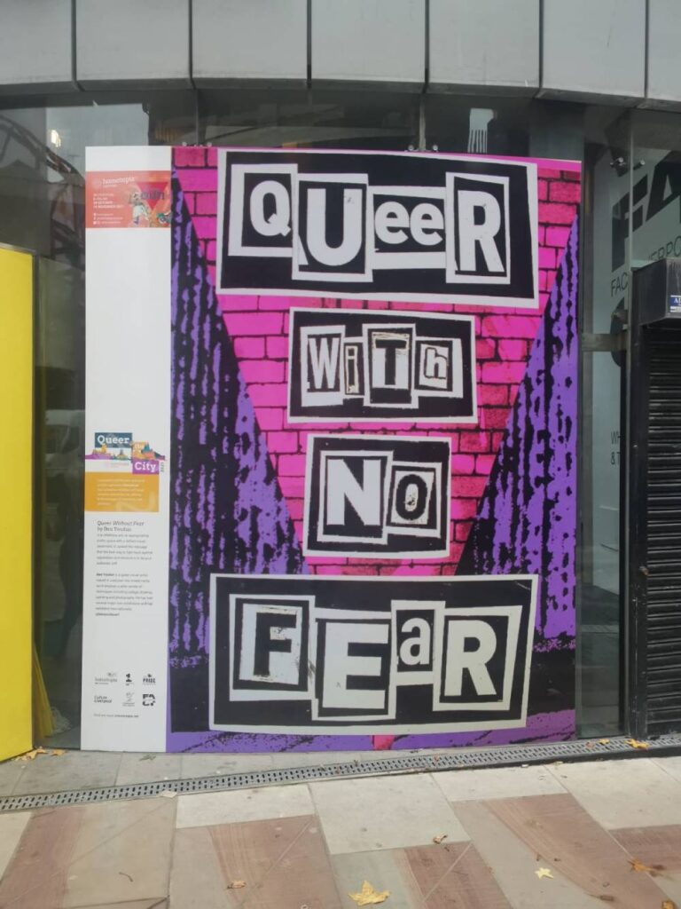 A picture of Ben Youdan's artwork that reads 'Queer with no fear' on display in a window