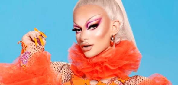 Krystal Versace poses in an orange outfit against a blue background