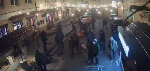 Several people in dark clothes are captured on camera destroying the outside of HvLv, a gay bar in Kyiv, Ukraine