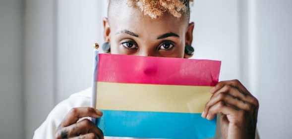 A person holds a pansexual pride flag