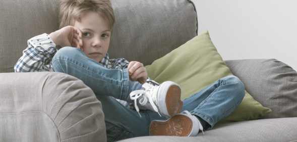 Sad boy sitting on an armchair