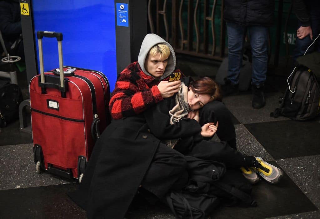 People use their phone as they take shelter in a metro station in Kyiv in the morning of February 24, 2022. 