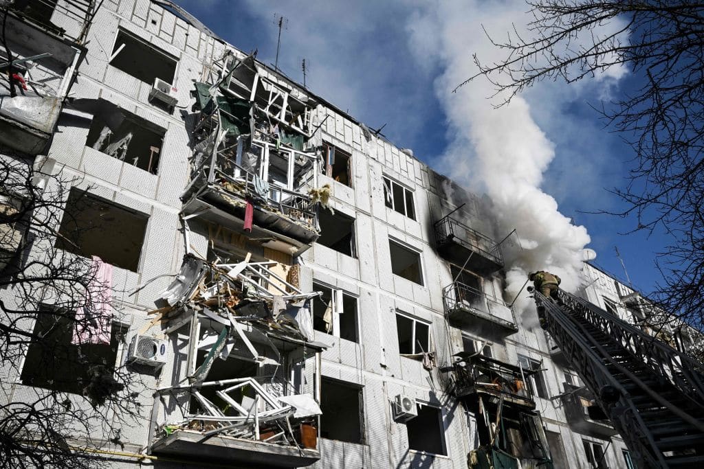 Firefighters work on a fire on a building after bombings on the eastern Ukraine town of Chuguiv on February 24, 2022, as Russian armed forces are trying to invade Ukraine from several directions.