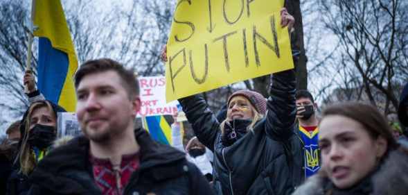 Activists hold placards and flags as they gather in Lafayette Square to protest Russia's invasion of Ukraine in Washington, DC.