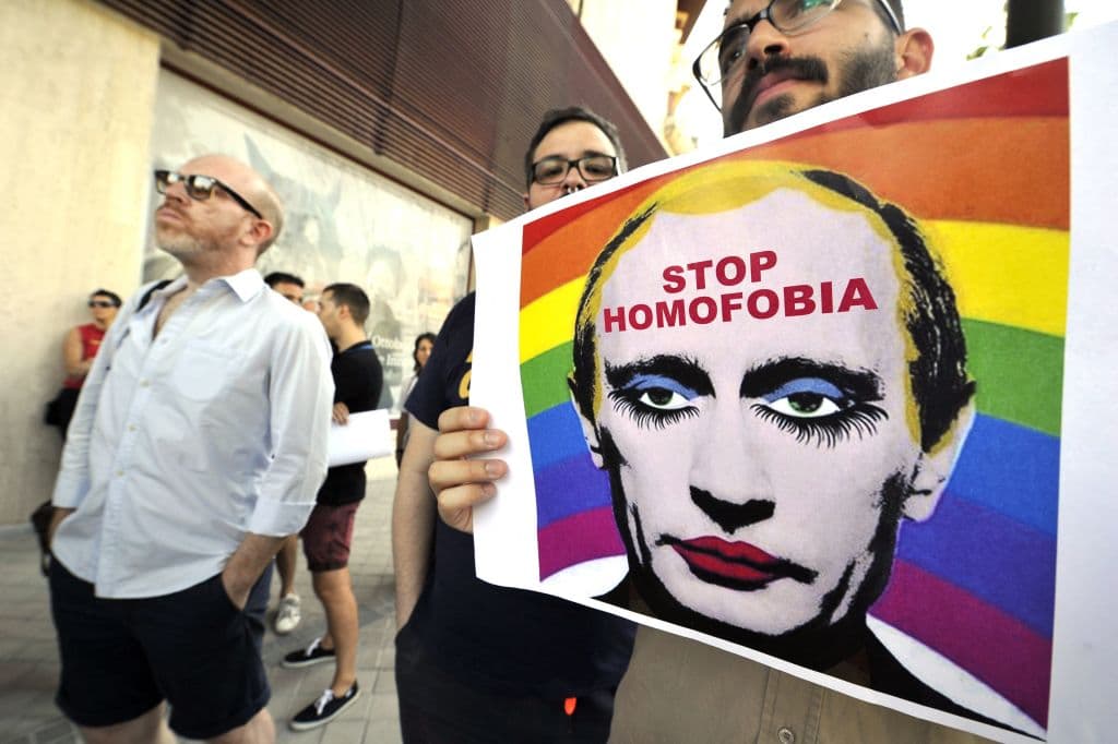 A demonstrator holds a poster depicting Russian President Vladimir Putin with make-up. 