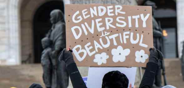 A protester holding a sign reading "gender diversity is beautiful