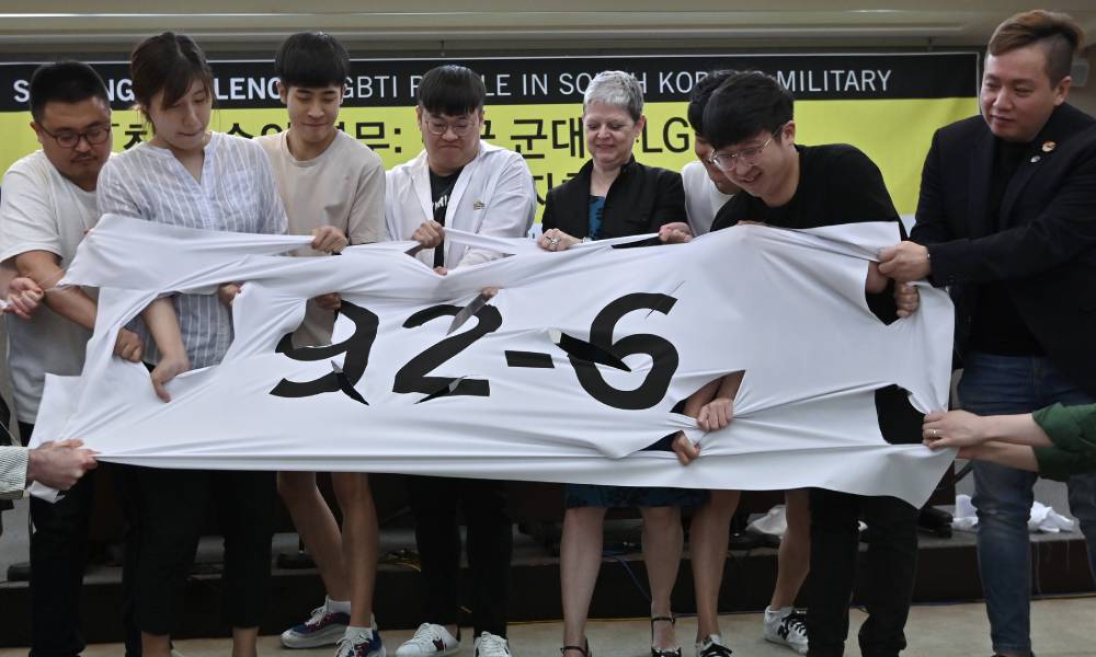 South Korean activists tear a banner calling for repeal of article 92-6 of the Military Criminal Act